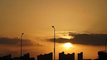 la splendida vista del tramonto con la silhouette e il cielo di nuvole colorate in città foto