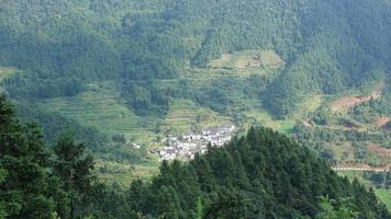 i bellissimi paesaggi di montagna con la foresta verde e il piccolo villaggio come sfondo nella campagna della Cina foto