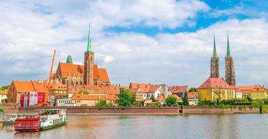 wroclaw, polonia, 7 maggio 2019 vista panoramica della collegiata di ostrow tumski santa croce e st. bartolomeo, cattedrale di s. Giovanni Battista e barche nel fiume odra oder nel centro storico della città foto