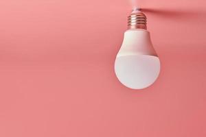 lampadina, copia spazio. concetto minimo di idea di risparmio energetico. sfondo rosa. foto