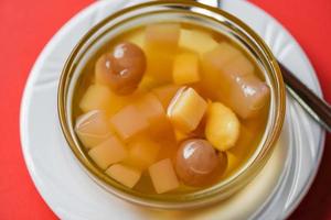 dessert cinesi, mix di noci di ginkgo sciroppo di manioca gelatina di cocco in succo di longan su una ciotola di vetro, zuppa di datteri tailandese e cinese di longan dolci asiatici foto