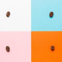 composizione di chicchi di caffè su sfondo bianco, blu, arancione e rosa. foto
