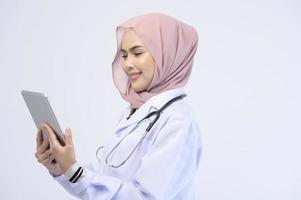 medico musulmano femminile con hijab su sfondo bianco studio.