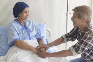 uomo anziano che visita una donna malata di cancro che indossa una sciarpa per la testa in ospedale, assistenza sanitaria e concetto medico foto