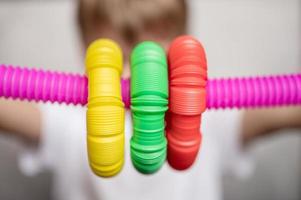 pop tube poptube kid giocattolo per bambini mani antistress che tengono giocando foto