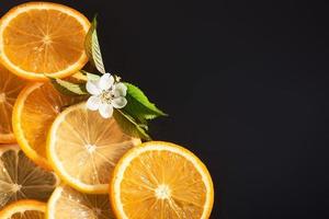 fette di arancia e limone, isolate su sfondo nero foto