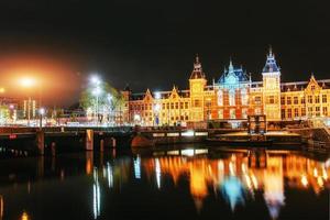 illuminazione notturna di edifici e barche vicino all'acqua nel canale. foto