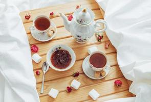 tazza di tè, teiera, cucchiaio e zucchero isolati foto