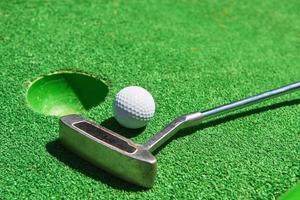 pallina da golf e mazza da golf su erba artificiale foto