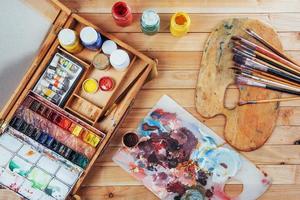 scatola di colori ad acquerello, pennelli artistici su tela. foto