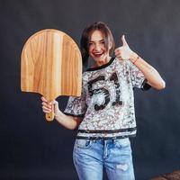 bella giovane donna con una tavola di legno foto