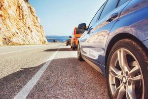 fantastica strada asfaltata lungo la costa e auto foto