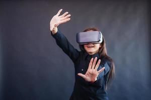 donna felice su sfondo nero in studio ottiene l'esperienza dell'utilizzo di cuffie per realtà virtuale con occhiali vr. foto