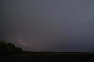 forte fulmine in tempesta nel campo foto