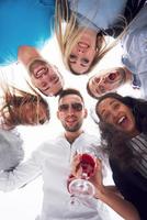 vacanze estive, persone felici - un gruppo di adolescenti che guardano in basso con un sorriso felice sul viso. foto