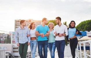 ritratto di un giovane e felice popolo a riposo sul molo. amici che si divertono a giocare sul lago. emozioni positive. foto