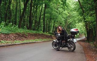 un'attraente ragazza sexy su una moto sportiva in posa all'esterno foto