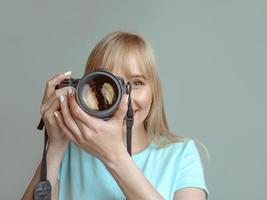 bionda elegante donna allegra fotografo con gli occhiali e tenendo la macchina fotografica. hobby, lavoro, concetto di ripresa foto