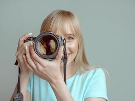 bionda elegante donna allegra fotografo con gli occhiali e tenendo la macchina fotografica. hobby, lavoro, concetto di ripresa foto