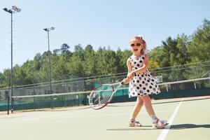 bambina felice che gioca a tennis foto