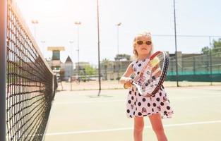 bambina felice che gioca a tennis foto