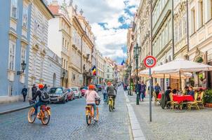 praga, repubblica ceca, 13 maggio 2019 persone turisti stanno andando in bicicletta biciclette su strada di ciottoli foto