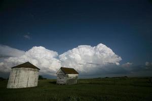 nuvole temporalesche dietro i vecchi granai del saskatchewan foto
