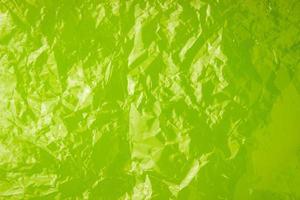 la trama del sacchetto di plastica su uno sfondo color lime. sacchetto trasparente stropicciato, plastica foto