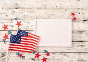 cornice bianca vuota per la progettazione di mockup su sfondo di legno bandiera nazionale americana foto