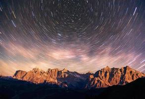 fantastica pioggia di meteoriti invernali e montagne nella nebbia foto