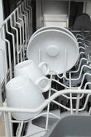 piatti bianchi in lavastoviglie. compiti con il concetto di lavastoviglie foto