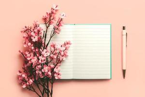 vista dall'alto del diario vuoto aperto con spazio per la copia, penna rosa e fiori di mandorlo foto