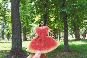 foto di concetto creativo di un cocomero come un vestito con una bella donna nel parco