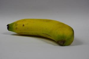 una banana gialla su sfondo grigio foto
