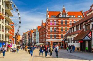 persone che camminano lungo la strada pedonale vicino alla grande ruota panoramica, tradizionali case tipiche edifici a Wroclaw foto