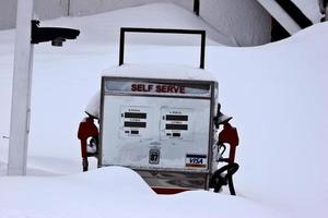 vecchia pompa di benzina ricoperta di neve foto