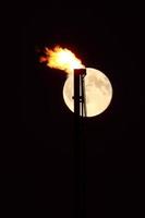 luna piena dietro la fiamma del gas naturale foto
