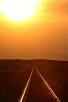 sole che tramonta illuminando i binari della ferrovia del saskatchewan foto