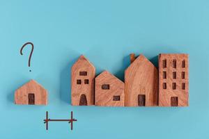 modello di casa in legno con domanda su sfondo isolato, comunità abitativa e concetto di distanza dell'alloggio. comunità domestica e sviluppo immobiliare futuro, concetti di casa di città per l'acquisto di decisioni. foto