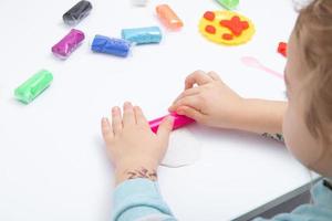 le mani dei bambini giocano la pasta per la creatività dei bambini. gioco da tavolo per lo sviluppo della motricità fine foto