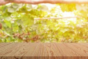 tavolo in legno vuoto su sfocatura dello sfondo del giardino dell'uva. per la visualizzazione del prodotto o per il layout visivo chiave di progettazione foto