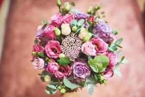 bellissimo bouquet da sposa legato con nastri di seta e pizzo con una chiave a forma di cuore. rose e rami di un ulivo sul vecchio sfondo vintage foto