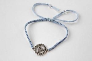 braccialetto intrecciato blu con chakra vishuddha su sfondo bianco foto
