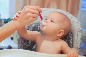 piccolo neonato sta mangiando il suo cibo. pappe, formule, puericultura foto