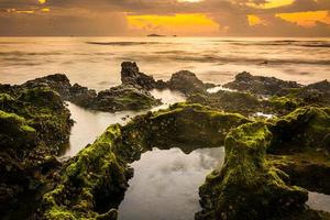 paesaggio al tramonto sulla spiaggia rocce in primo piano foto