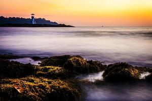 faro luminoso khao lak, bellissimo tramonto sulla spiaggia di nang thong, khao lak, thailandia. tramonto tropicale colorato con cielo nuvoloso. modelli trama di sabbia sulla spiaggia, mare delle Andamane phang nga thailandia foto