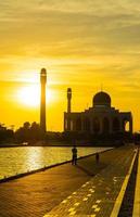 la moschea centrale di Songkhla dal giorno alla notte con cieli colorati al tramonto e le luci della moschea e i riflessi nell'acqua nel concetto di paesaggio di riferimento foto