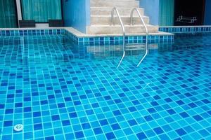 scala di piscina con acqua blu foto