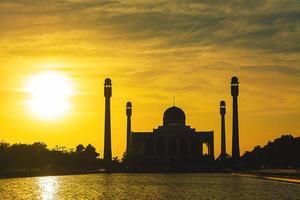 la moschea centrale di Songkhla dal giorno alla notte con cieli colorati al tramonto e le luci della moschea e i riflessi nell'acqua nel concetto di paesaggio di riferimento foto