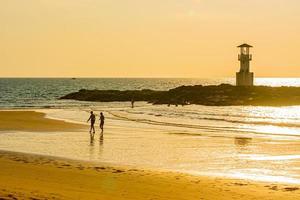 faro luminoso khao lak, bellissimo tramonto sulla spiaggia di nang thong, khao lak, thailandia. tramonto tropicale colorato con cielo nuvoloso. modelli trama di sabbia sulla spiaggia, mare delle Andamane phang nga thailandia foto